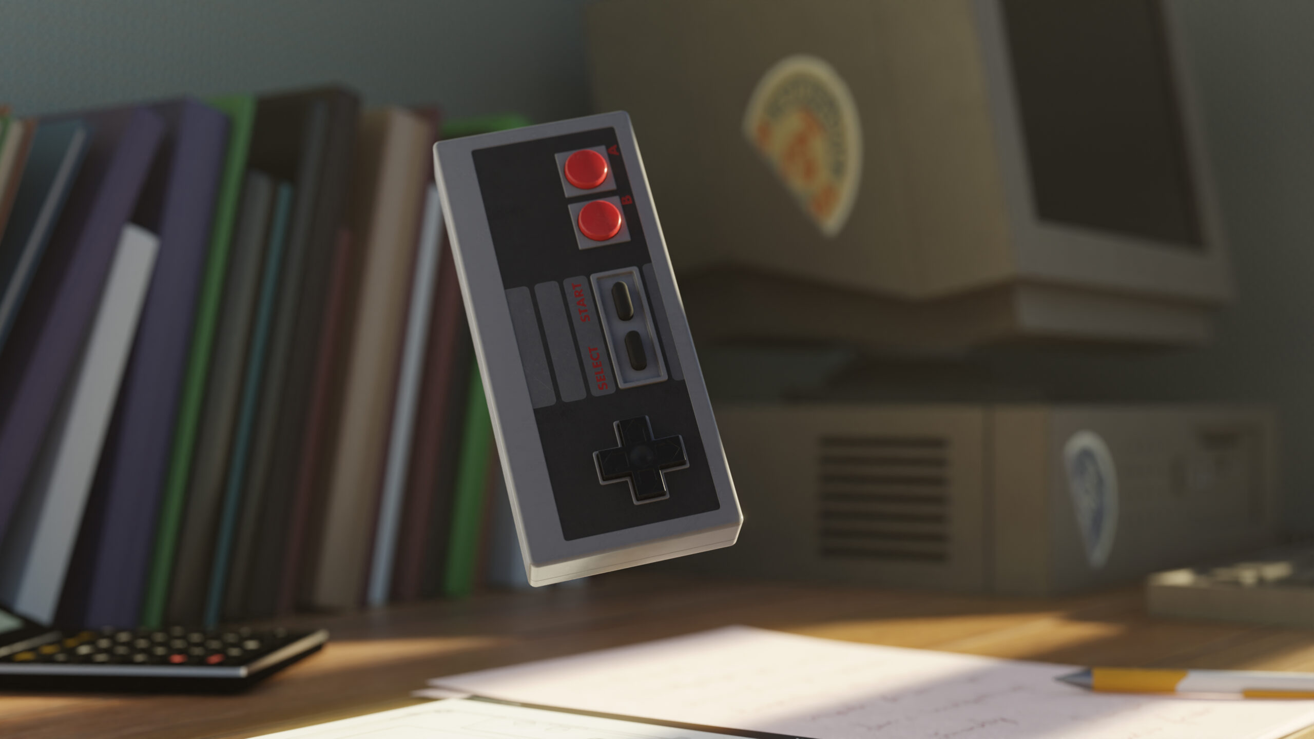 Control retro de videojuego clásico suspendido en el aire frente a una computadora antigua y libros apilados sobre un escritorio.